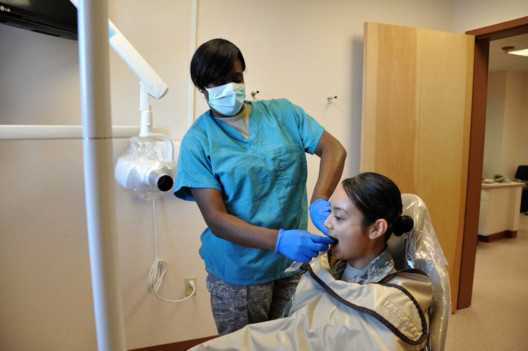 (Left) Tech. Sgt. Myisha Millsap, 926th Aerospace Medicine Squadron non-commissioned officer in charge of dental, prepares to take x-rays of the first patient to use the newly constructed dental clinic Nov. 2. (U.S. Air Force photo/Maj. Jessica Martin)