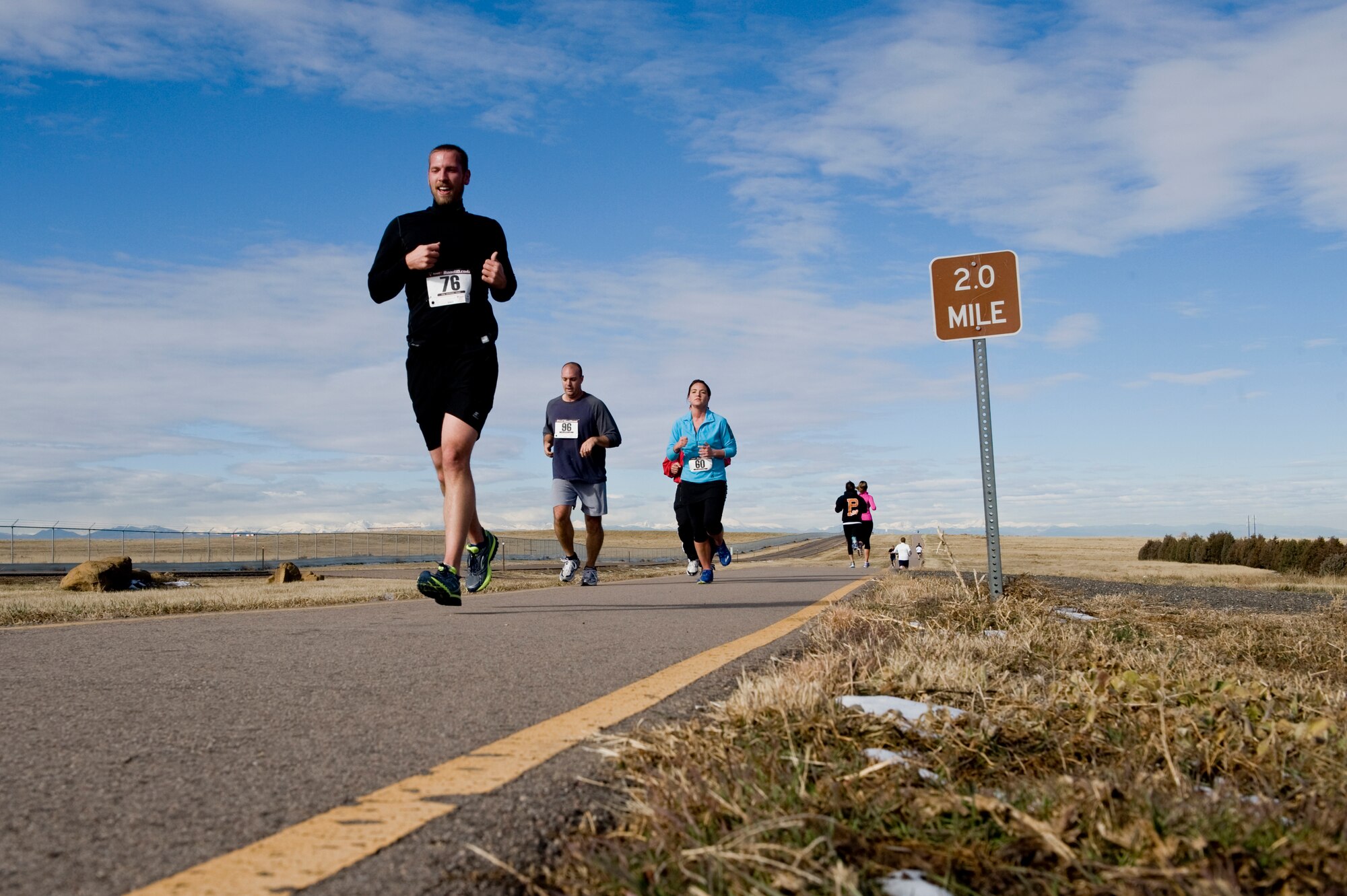 Turkey Trot competitors speed past the 2-mile marker Nov. 26, 2013, on Buckley Air Force Base, Colo. During the competition, 19 Team Buckley members competed with the fastest runners in each category given turkeys as prizes.  (U.S. Air Force photo by Senior Airman Phillip Houk/Released)