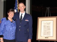 Chaplain (Capt.) Mark Hunsinger and his wife, Kim Hunsinger, pose alongside a framed page of the Bible during the Witherspoon Award ceremony in New York City, Nov.21, 2013. The National Bible Association gives the award for excellence in demonstrating and promoting reading of the Scriptures. (Courtesy photo)