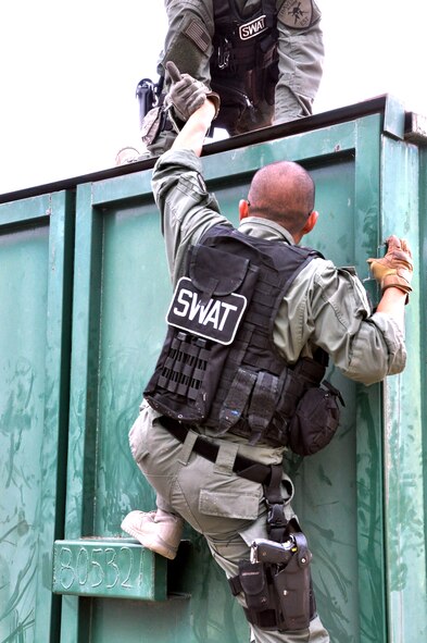 Members of the Travis Emergency Services Team help each other scale a conex in the Jungle Trail course Sep. 13 in San Jose. The Airmen were competing in the Best in the West SWAT competition against 35 other SWAT teams from the West Coast.(U.S. Air Force photo/Staff Sgt. Patrick Harrower)