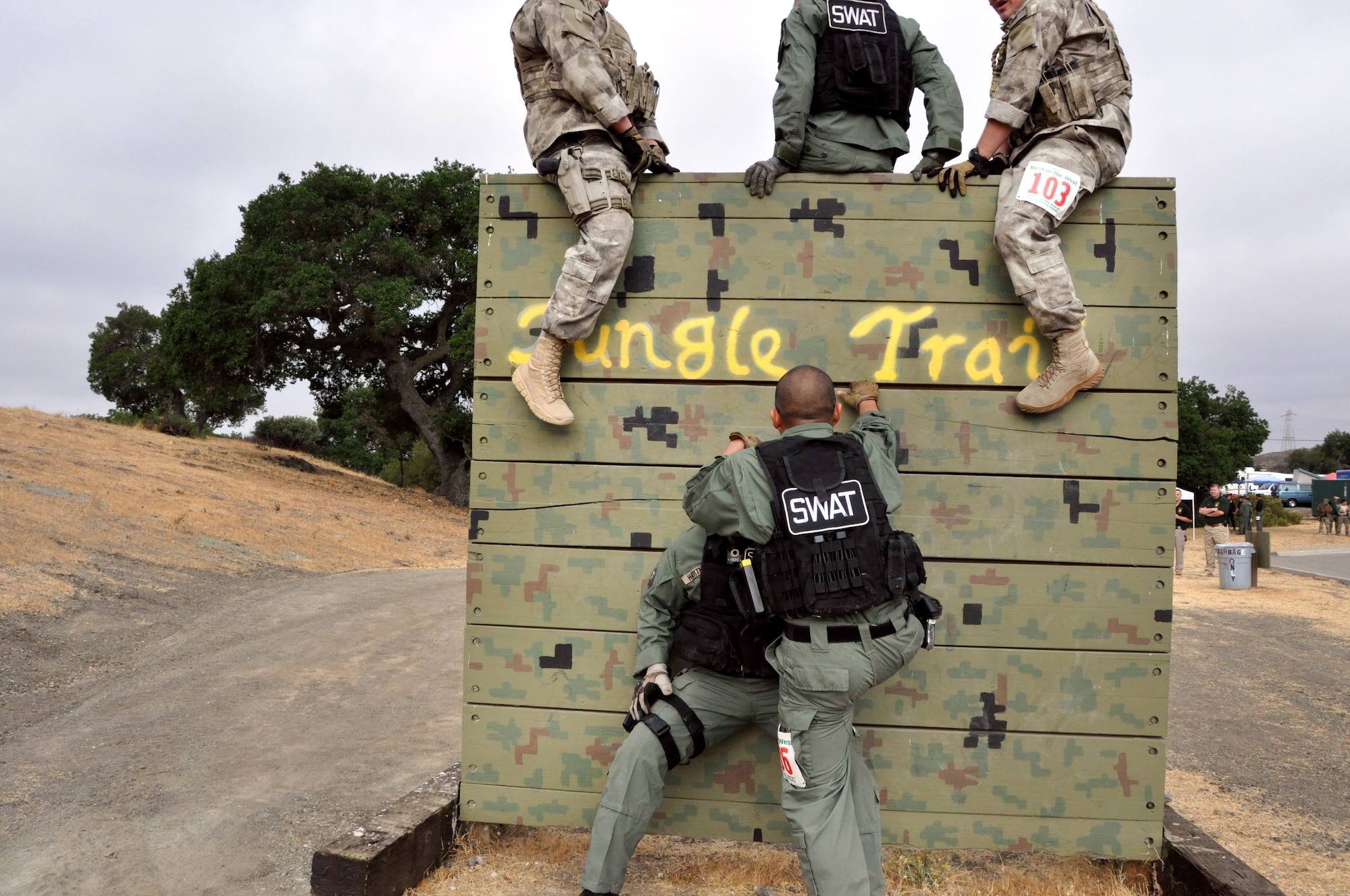 Members of the Travis Emergency Services Team help each other scale a wall in the Jungle Trail course last week in San Jose. The Airmen were competing in the Best in the West SWAT competition against 35 other SWAT teams from the West Coast.(U.S. Air Force photo/Staff Sgt. Patrick Harrower)