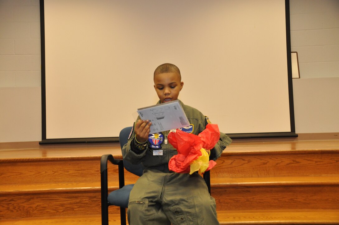 Ne’Veah Littleton stares in surprise as he received an iPad mini from the Fischer House, during a day in which Ne’Veah was appointed a pilot for the Pilot for a Day program Joint Base Andrews, Md., November 22, 2013. Ne’Veah is a terminally ill child diagnosed with Diffuse Intrinsic Pontine Glioma, which is a tumor on the brain stem. (U.S. Air Force photo/ Staff Sgt. Katie Spencer)