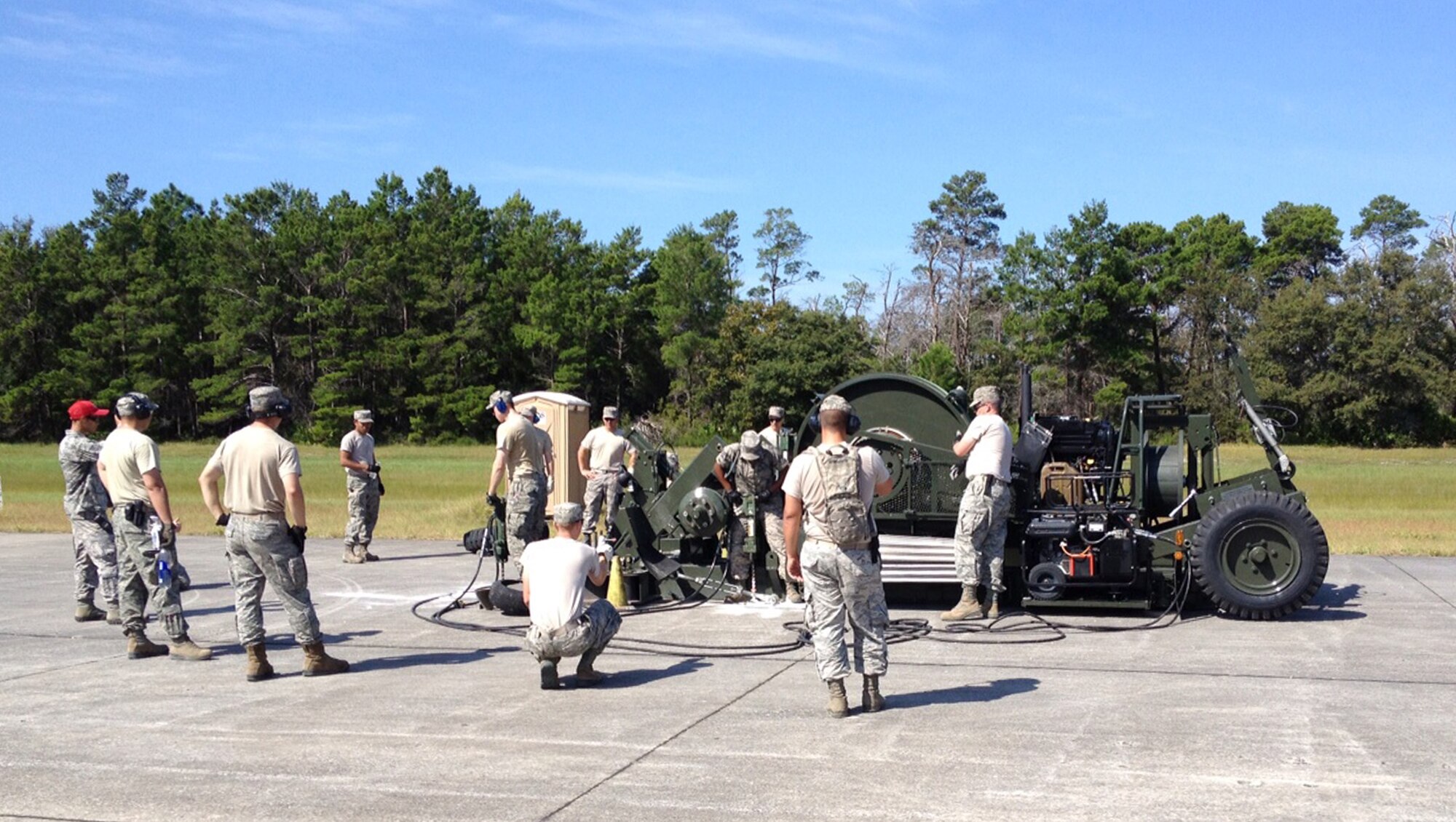 Troops from the Kentucky Air National Guard’s 123rd Civil Engineer Squadron join with other Airmen to anchor a Mobile Aircraft Arresting System at Tyndall Air Force Base, Fla., on Sept 16, 2013. The Kentucky Air Guardsmen were participating in Silver Flag, a week-long exercise to train and test the skills of civil engineers at a bare-base location in a simulated wartime environment. (U.S. Air National Guard photo by Tech. Sgt. Dave Soldat)