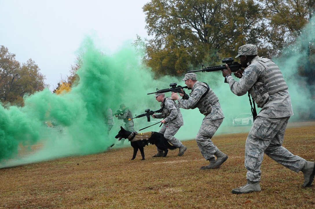 Members of the 14th Security Forces Squadron perform a tactical movement with the help of military working dog, Maci, at the Military Working Dog Demonstration Nov. 22 outside of the Columbus Club. (U.S. Air Force Photo/Senior Airman Kaleb Snay)