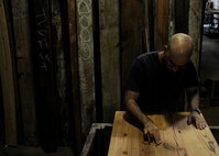 Peter Martin, woodworking apprentice, sands a tabletop at Sandtown Millworks in Baltimore, Md., Aug. 16, 2013.  Martin used sandpaper to level the tabletop surface.  (U.S. Air Force photo by Tech. Sgt. Jasmin Taylor)