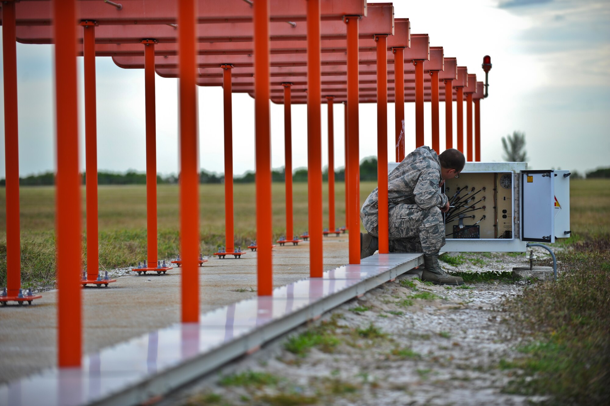 Senior Airman Scott Phillips, 6th Communications Squadron airfield systems technician, tightens radio frequency cable connections to the localizer at MacDill Air Force Base, Fla., Nov. 15, 2013. The localizer, one of many pieces of equipment that airfield systems Airmen maintain, is a critical air traffic control and landing system. (U.S. Air Force photo by Airman 1st Class Ned T. Johnston/Released)