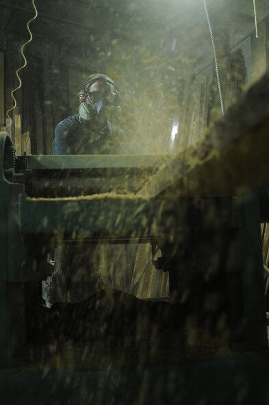 James Klausmeyer, shop manager, uses the planer at Sandtown Millworks in Baltimore, Md., Aug. 14, 2013.  Klausmeyer used the planer to shave off the old layer of wood revealing a new surface.  (U.S. Air Force photo by Tech. Sgt. Jasmin Taylor)