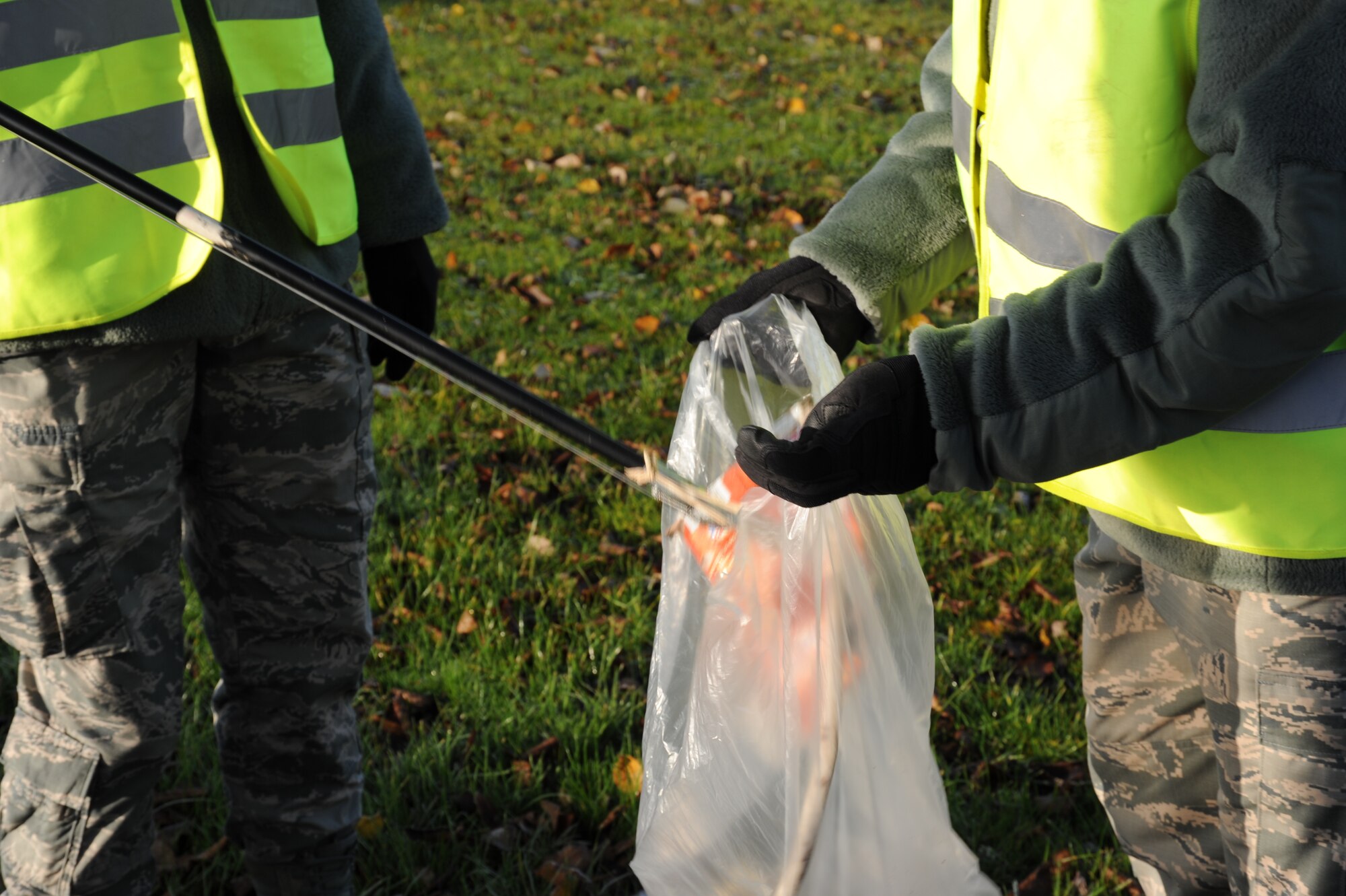 SPANGDAHLEM AIR BASE, Germany -- An Airman puts a piece of trash in a trash bag during a morning trash route along Perimeter Road Nov. 25, 2013. Eifel Pride is a year-round program used for base beautification by first-term Airmen. The program also allows the Airmen to attend the many initial appointments and briefings. (U.S. Air Force photo by Airman 1st Class Dylan Nuckolls/Released)