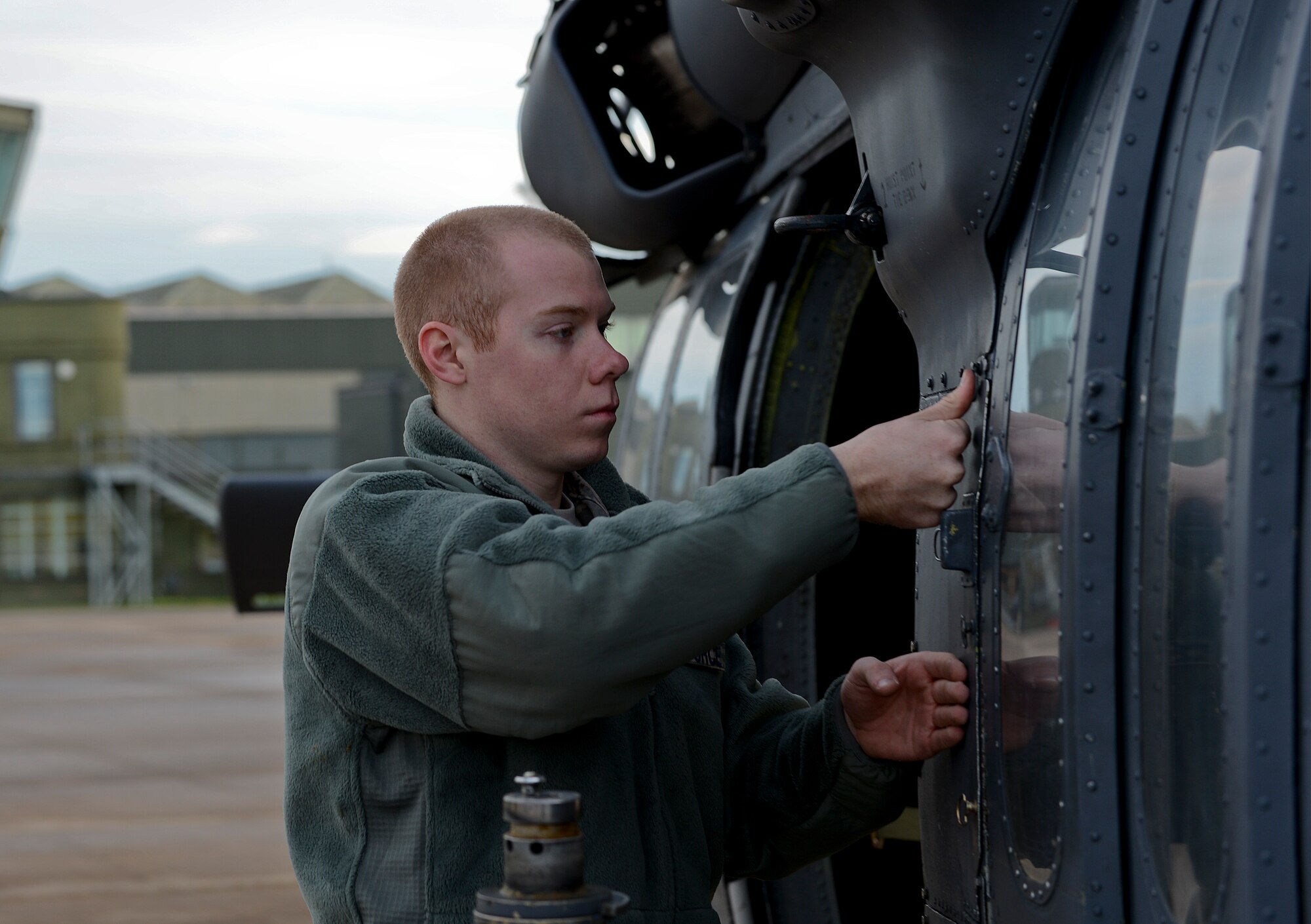 Airman 1st Class Tyler Busk, 748th Aircraft Maintenance Squadron HH-60G Pave Hawk crew chief, performs maintenance on a Pave Hawk at Royal Air Force Leeming, England, Nov. 18, 2013. The 56th Rescue Squadron and 748th AMXS participated in electronic warfare training over the RAF Spadeadam test range Nov. 18-22. Throughout the week, they honed their skills engaging potential threats. (U.S. Air Force photo by Airman 1st Class Trevor T. McBride/Released)