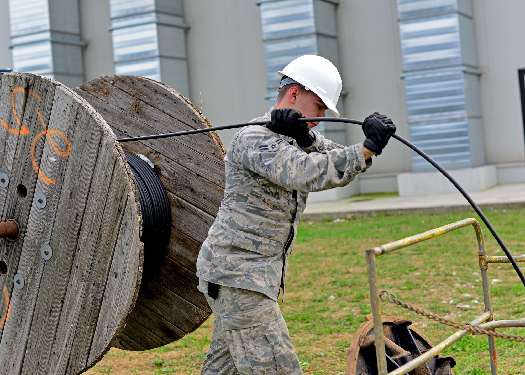 Airman 1st Class Austin Johnson, 31st Communications Squadron cable systems apprentice, pulls a line of cable into a manhole, Nov. 13, 2013, at Aviano Air Base, Italy. “Cable Dawgs” maintain more than 20,000 miles of cable fiber throughout the base connecting Team Aviano to 14 geographically- separated units. (U.S. Air Force photo/Senior Airman Briana Jones)