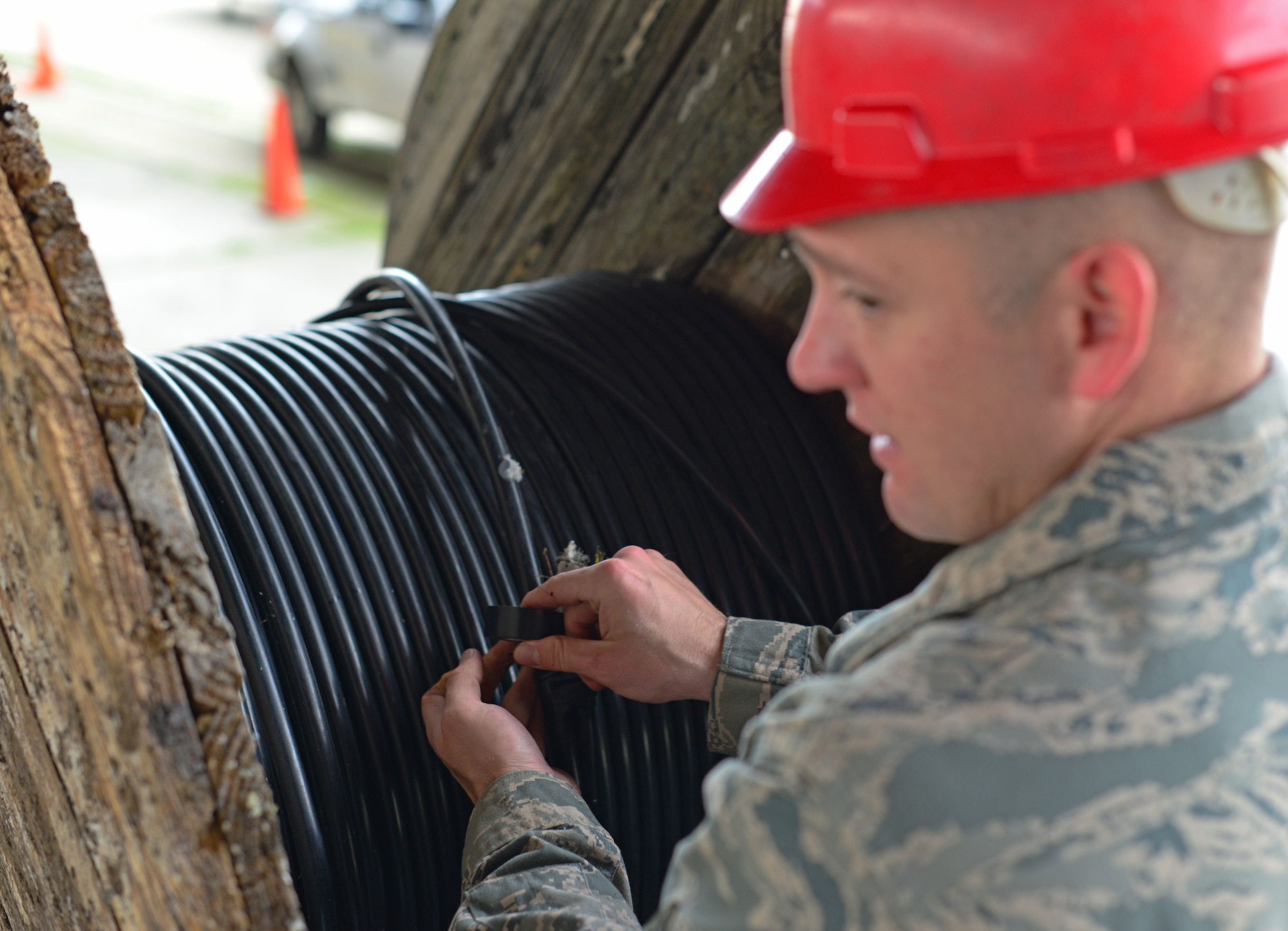 Staff Sgt. Scott Gingrich, 31st Communications Squadron cable and maintenance supervisor ties off a reel of cable, Nov. 13, at Aviano Air Base, Italy. Recently, “Cable Dawgs” helped the Italian Air Force form a new communication infrastructure system. The project helped save $20 million in contracting costs and was completed in six months. (U.S. Air Force photo/Senior Airman Briana Jones)