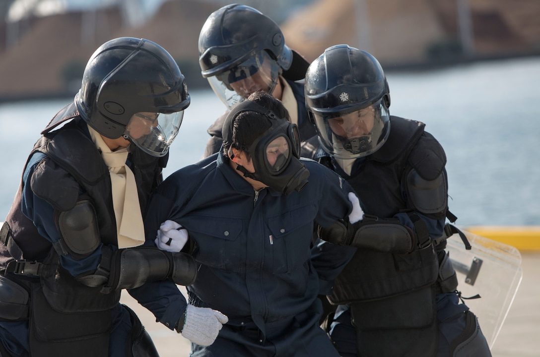 Yamaguchi Prefectural Police Headquarters riot squad personnel apprehend an assailant during a simulated anti-terrorism exercise at Muronoki pier, Iwakuni harbor, Iwakuni, Japan, Nov. 22, 2013. Iwakuni Police Department, Coast Guard and Customs hosted the exercise to show their capabilities when dealing with terroristic threats.