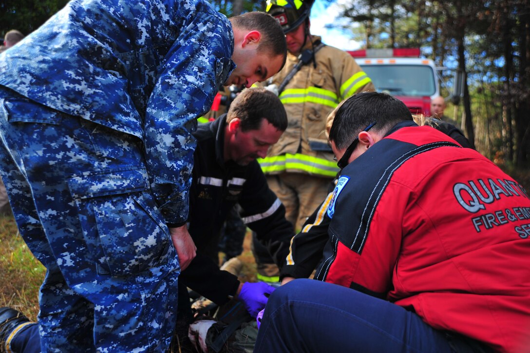 Firemen, Marines, corpsmen and Protected Health Information Air Medical members prepare awounded role player for aerial transportation to a hospital, during a training exercise at Camp Goettge aboard Marine Corps Base Quantico on Nov. 19, 2013. 