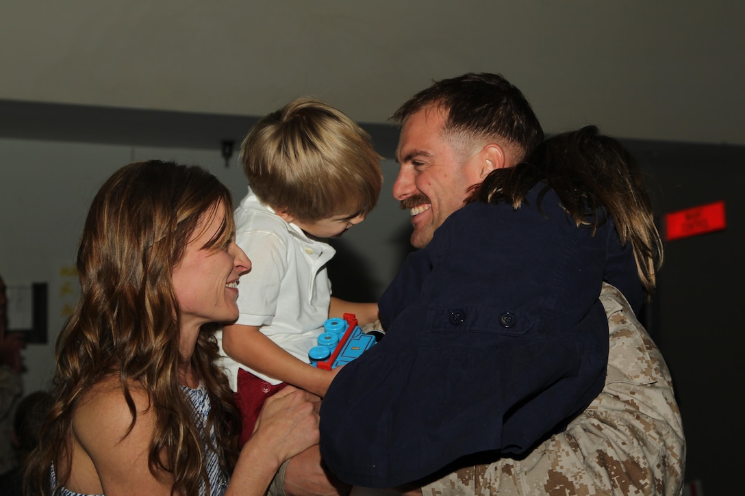 Capt. Caleb Joiner, unmanned aerial vehicle mission commander, Unmanned Aerial Vehicle Squadron 1, is reunited with his wife, Shera, and children, Savannah, 4, and Miles, 3, during the squadron's homecoming at the VMU-1 hangar Nov. 22, 2013.