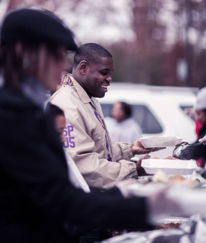 Captain Andrew Holmes, the market research analysis officer at Marine Corps Recruiting Command, hands out food trays to homeless individuals living in the Woodbridge, Va. area, Nov. 23, 2013. In addition to winning our nation's battles abroad, U.S. Marines pride themselves in giving back to their communities at home.