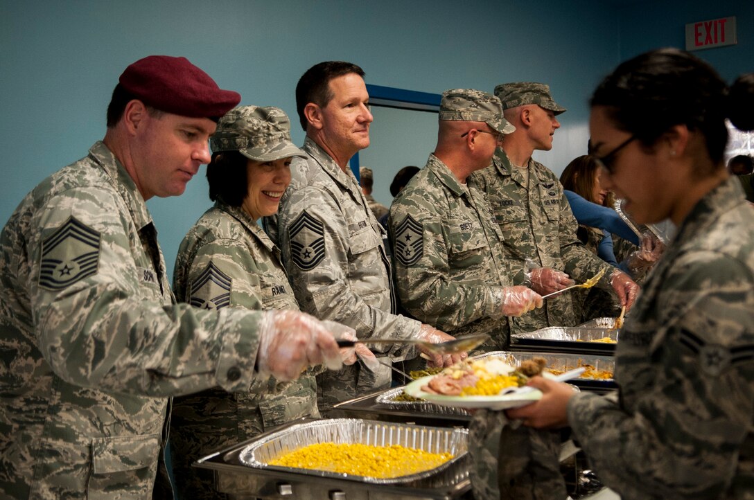 Senior NCOs and officers serve food to Airmen during the Thanksgiving luncheon Nov. 21, 2013, at Moody Air Force Base, Ga. The Thanksgiving meal enforced esprit de corps and supported Airmen who celebrate the holidays without their families. 