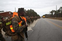 Lance Cpl. Willie J. Pickens, a supply administration and operations specialist with Ragnarok Company, 2nd Supply Battalion, 2nd Marine Logistics Group, stands guard to alert traffic at an intersection during a five-mile hike aboard Camp Lejeune, N.C., Nov. 26, 2013. The hike built a sense of accomplishment and companionship within Ragnarok Co., which is comprised of Marines and sailors from different units within the MLG. (U.S. Marine Corps photo by Lance Cpl. Sullivan Laramie)