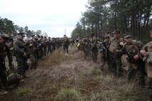 Marines and sailors with Ragnarok Company, 2nd Supply Battalion, 2nd Marine Logistics Group stop for a 10-minute rest at the halfway point during a five-mile hike aboard Camp Lejeune, N.C., Nov. 26, 2013. The service members completed the first of several conditioning hikes to build physical and mental endurance, and teamwork within the company prior to an upcoming mission to Norway. (U.S. Marine Corps photo by Lance Cpl. Sullivan Laramie)