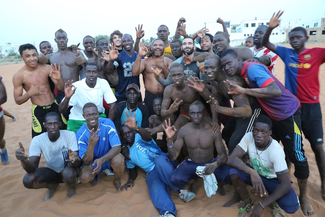 Koa team members, wrestlers and the Grand Yoff Mbolo training cadre pose at the end of an engagement to introduce KOA team members to Senegalese traditional "laamb" wrestling in Dakar, Senegal, on Nov. 5, 2013.  