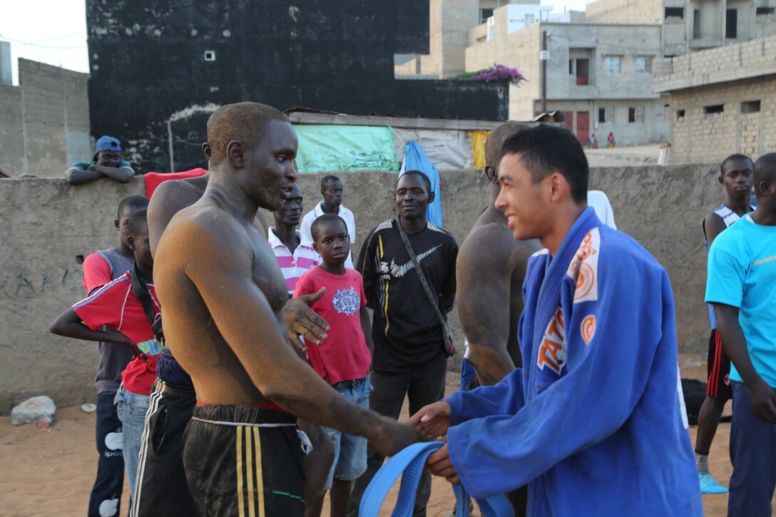 Malick and a traditional "laamb" wrestler exchange a show of respect prior to a Lion Heart Initiative cross-training engagement at Grand Yoff Mbolo Training Center in Dakar, Senegal, on Nov. 5, 2013. 