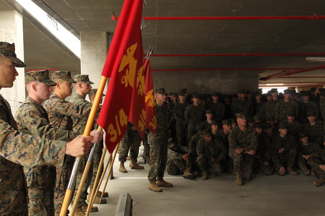 Sgt. Maj. Michael Miller, battalion sergeant major, 3rd Battalion, 4th Marines, 7th Marine Regiment, stands alongside the battalion's company guidons after a purple heart award ceremony Nov. 22. 2013.