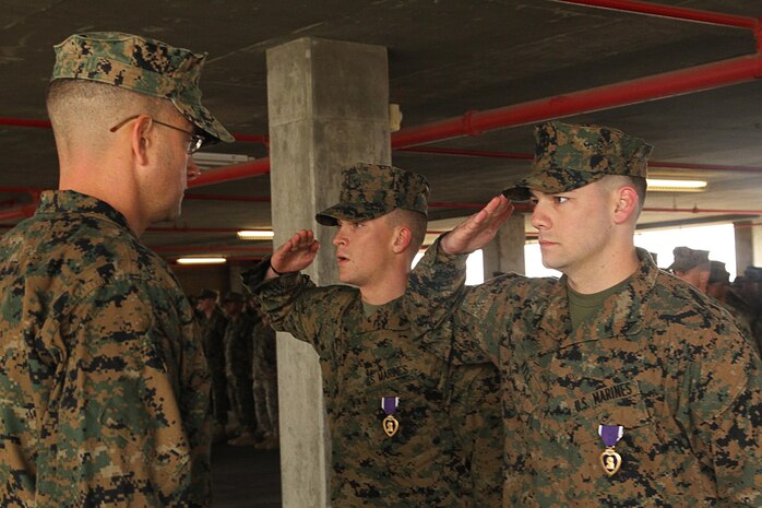 Lance Cpl. Devin H. Kyle, assaultman, and Cpl. Samuel B. Burkeland, team leader, with 3rd Battalion, 4th Marines, 7th Marine Regiment, are awarded the Purple Heart medal aboard the Combat Center Nov. 22, 2013.