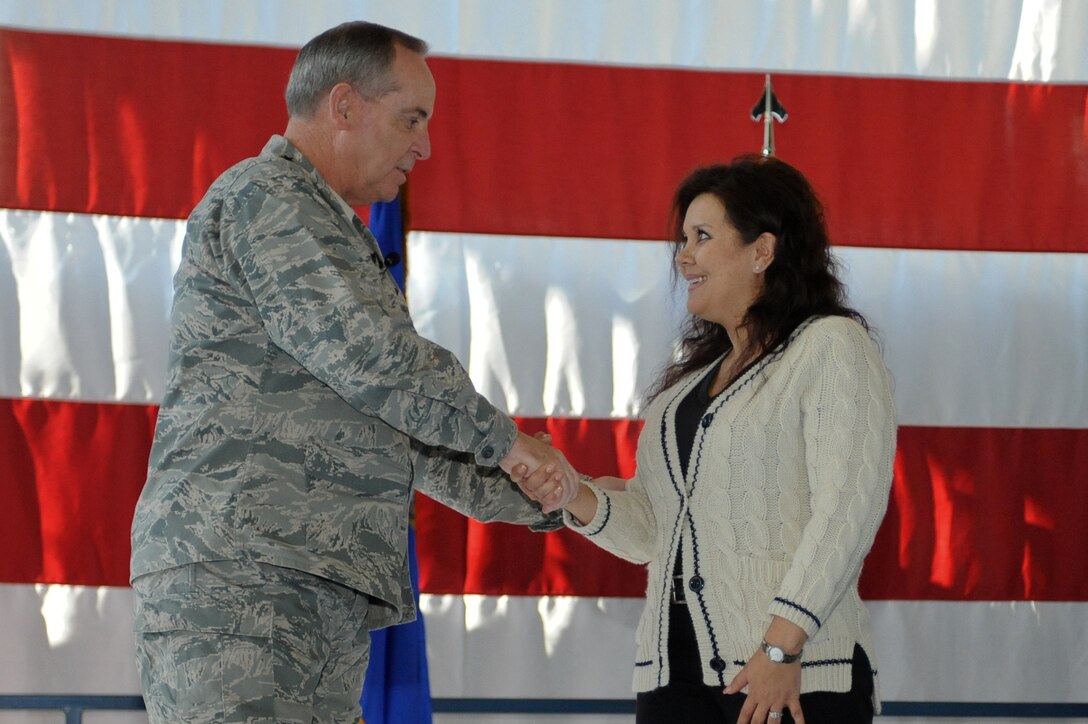 Air Force chief of staff, Gen. Mark A. Welsh III, coins Glenda Johnson, 28th Maintenance Group Analyst Section chief, for her service during an all call at Ellsworth Air Force Base, S.D., Nov. 26, 2013. Johnson has served at Ellsworth for more than 10 years and was recognized and coined by Welsh for her 18 years of service in the Air Force. (U.S. Air Force photo by Senior Airman Alystria Maurer/Released)