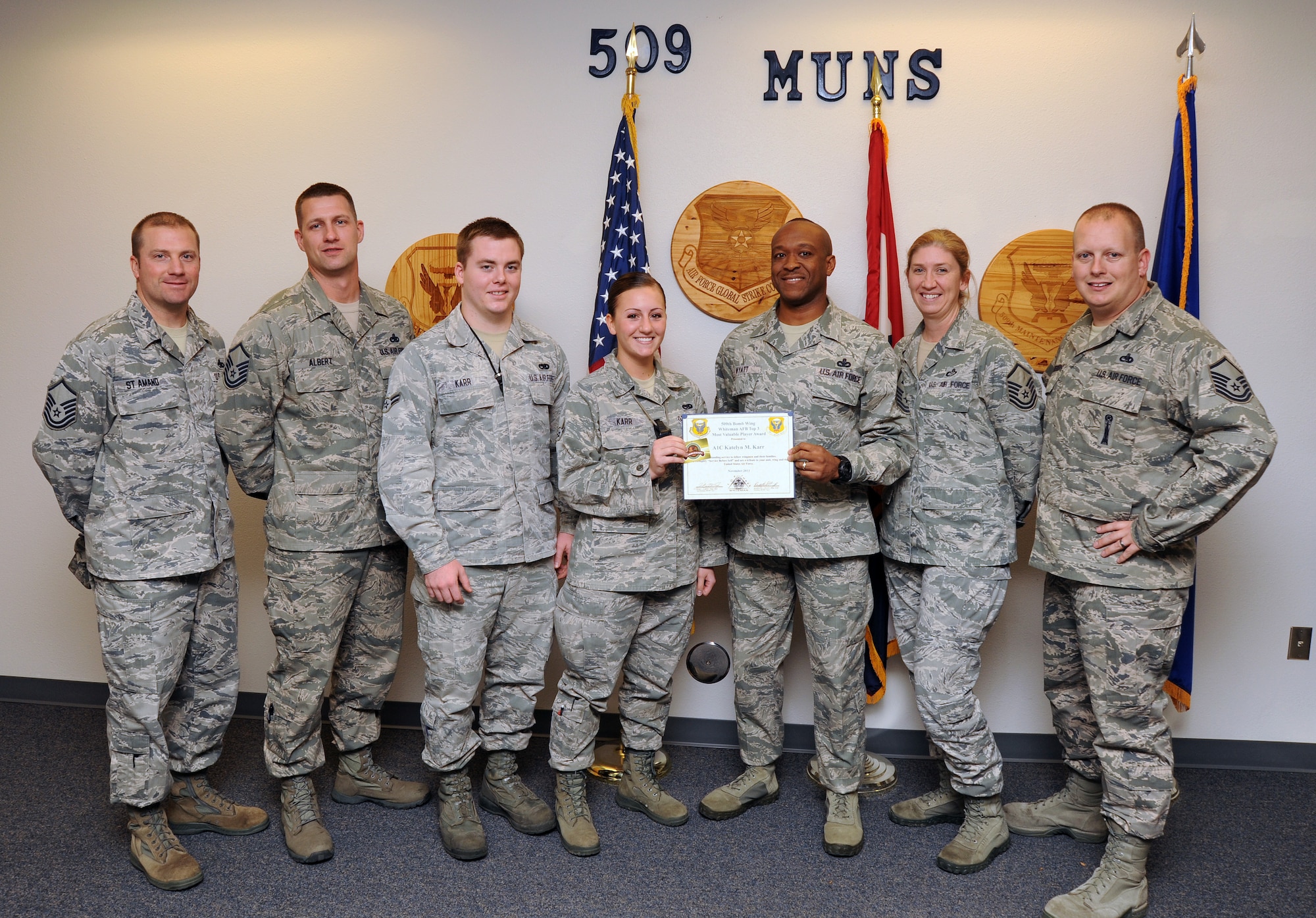Airman 1st Class Katelyn Karr, 509th Munitions Squadron armament systems team member, receives the Top III MVP award for November at Whiteman Air Force Base, Mo., Nov. 21, 2013. Some of the accomplishments that contributed to her award include supporting more than 100 veterans for a wheelchair washing initiative and completing her career development course books three months early. (U.S. Air Force photo by Staff Sgt. Nick Wilson/Released)