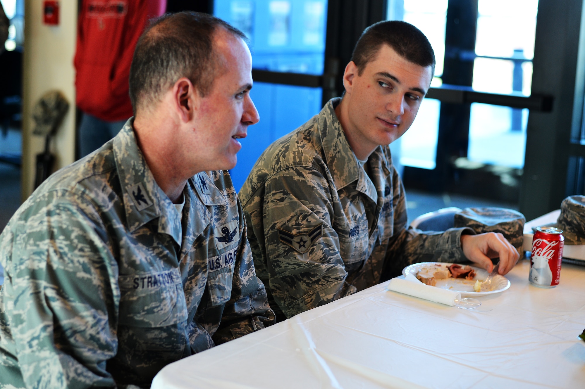Col. Mitchell Stratton, 460th Space Wing vice commander, left, visits with Airman 1st Class Tyler Ross, 566th Intelligence Squadron, during a turkey dinner Nov. 27, 2013, at Patriot Hall on Buckley Air Force Base, Colo. Dorm residents were treated to a Thanksgiving dinner prepared and served by their senior leadership.  (U.S. Air Force photo by Senior Airman Riley Johnson/Released)