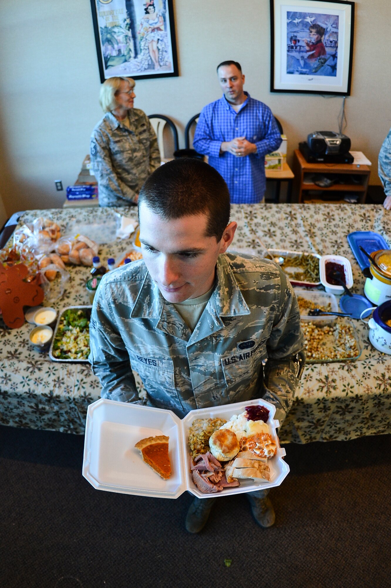 Senior Airman Louis Reyes, 566th Intelligence Squadron, searches for a place to dine Nov. 27, 2013, at Patriot Hall on Buckley Air Force Base, Colo. Dorm residents were treated to a Thanksgiving dinner prepared and served by their senior leadership.  (U.S. Air Force photo by Senior Airman Riley Johnson/Released)