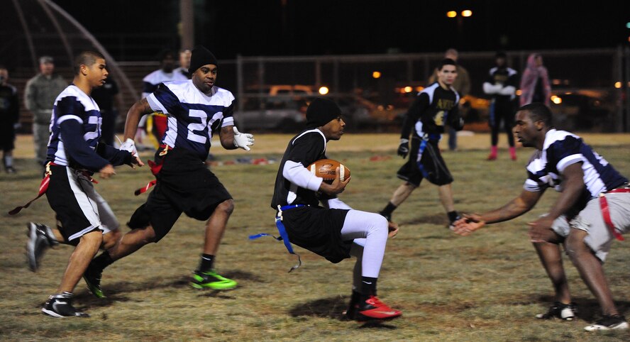 Lester Jones, 509th Aircraft Maintenance Squadron Dragons quarterback, performs a juke move to evade defenders during an intramural flag football championship game against the 509th Force Support Squadron at Whiteman Air Force Base, Mo., Nov. 15, 2013. Jones passed for two touchdowns and ran for another. (U.S. Air Force photo by Staff Sgt. Nick Wilson/Released)