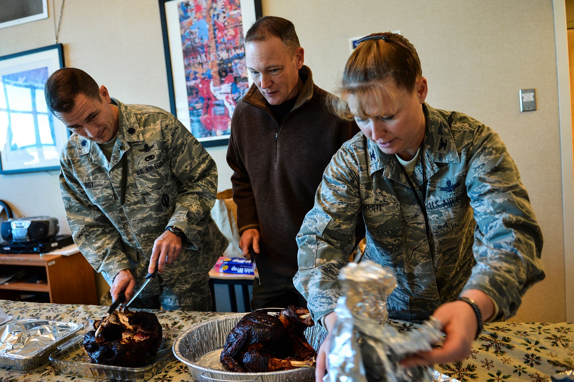 Lt. Col. Francois Roy, 2nd Space Warning Squadron commander, left; Navy Capt. Craig Oldham, Naval Operational Support Center–Denver commander, center; and Col. DeAnna, Burt 460th Operations Group commander, prepare turkey for dorm residents Nov. 27, 2013, at Patriot Hall on Buckley Air Force Base, Colo. Dorm residents were treated to a Thanksgiving dinner prepared and served by their senior leadership.  (U.S. Air Force photo by Senior Airman Riley Johnson/Released)