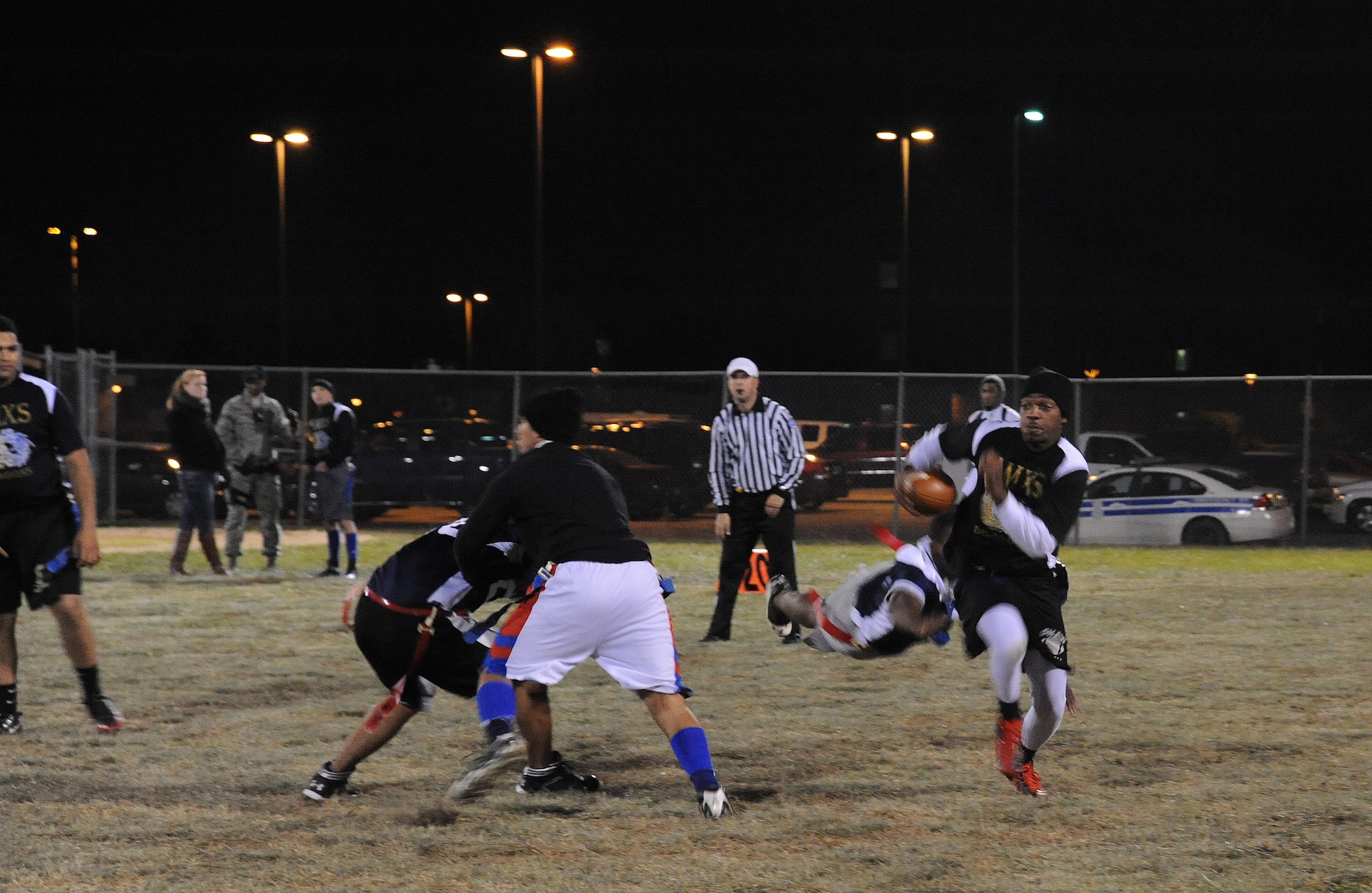 Lester Jones, 509th Aircraft Maintenance Squadron Dragons quarterback, attempts to evade defenders during an intramural flag football game against the 509th Force Support Squadron at Whiteman Air Force Base, Mo., Nov. 15, 2013. The Dragons defeated the 509th FSS in the fourth quarter 28-26. (U.S. Air Force photo by Staff Sgt. Nick Wilson/Released)