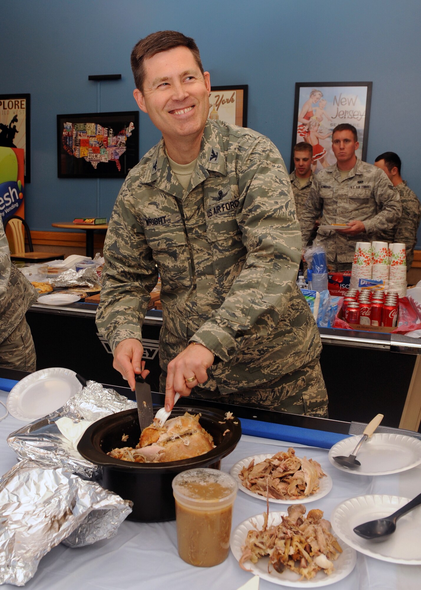 Col. Dan Wright, 460th Space Wing commander, carves a turkey, Nov. 27, 2013, at the Panther Hall Dorm on Buckley Air Force Base, Colo. This is an annual tradition to ensure wellness, show thanks to and provide a home-cooked meal for Airmen, Soldiers, Sailors, Marines and Coast Guardsmen in the dorm. (U.S. Air Force photo by Senior Airman Marcy Copeland/Released)  