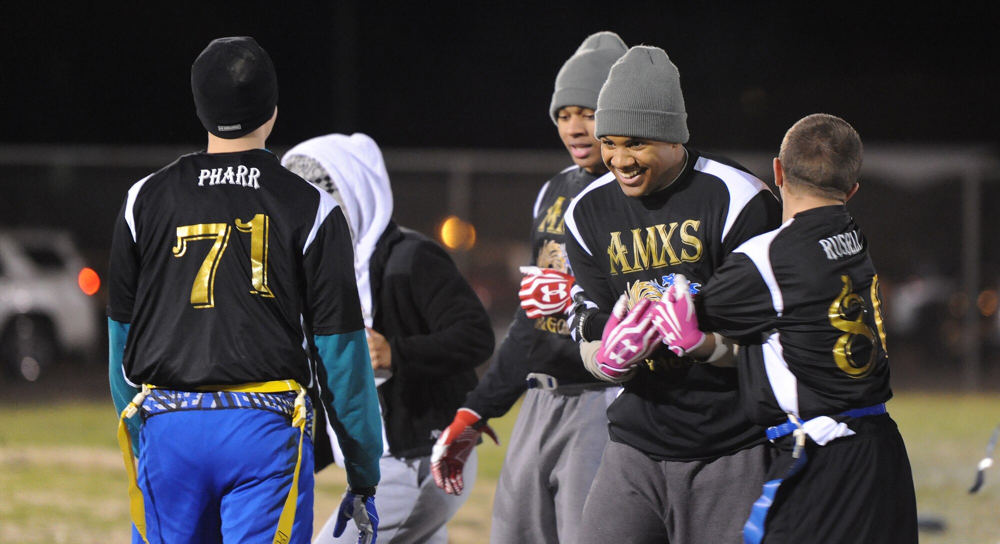 Isaaic More, 509th Aircraft Maintenance Squadron Dragons defensive back, celebrates with teammates after intercepting the ball during an intramural flag football playoff game against the Operations Support Squadron at Whiteman Air Force Base, Mo., Nov. 14, 2013. The Dragons defeated OSS 38-6 to move up to the final round of the semifinals. (U.S. Air Force photo by Staff Sgt. Nick Wilson/Released)