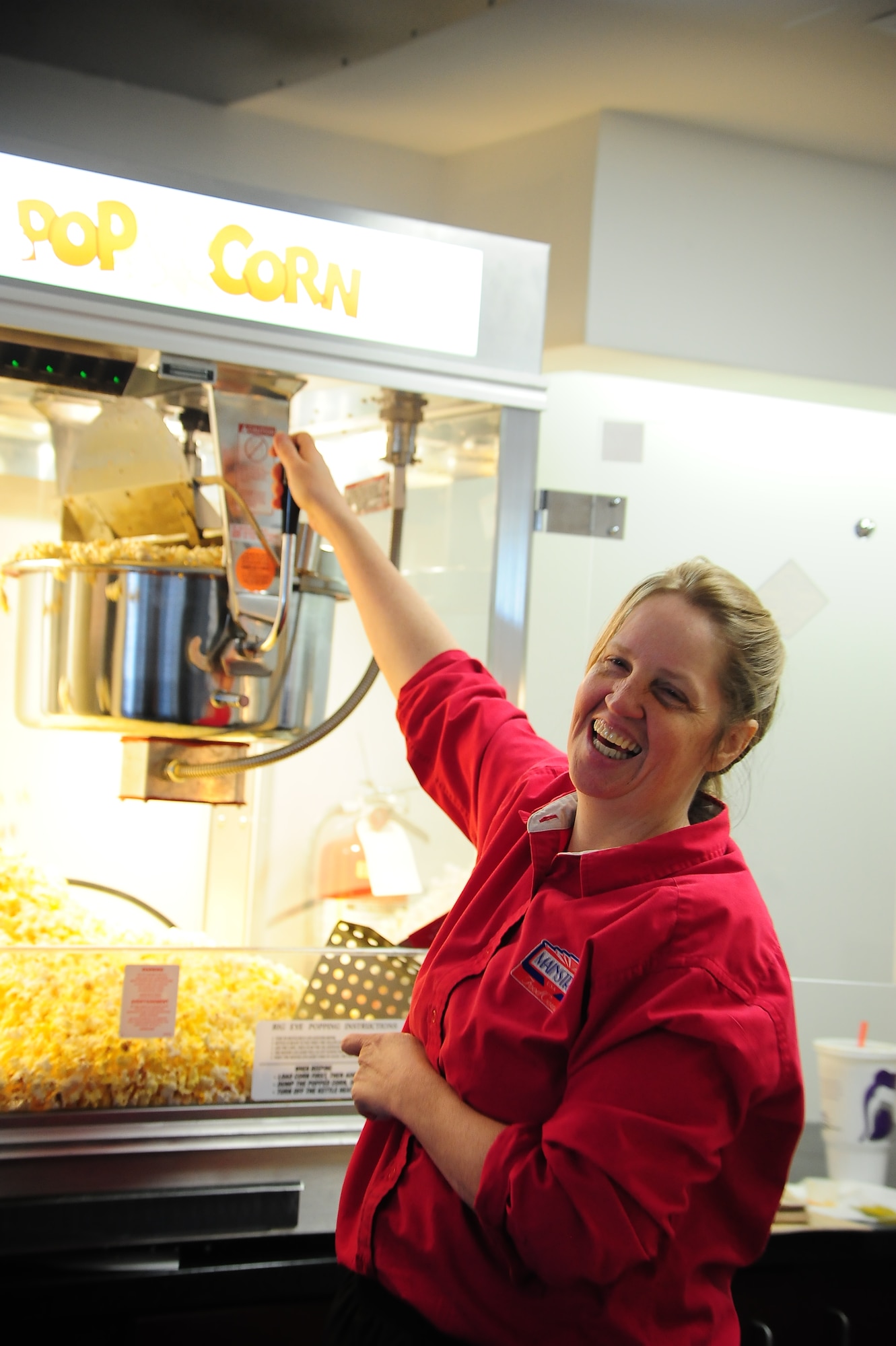 Tina Piper, Army and Air Force Exchange Service food court manager, uses the new popcorn maker for the first time at the Whiteman Theater grand re-opening Nov. 27, 2013, at Whiteman Air Force Base. Having a theater nearby is convenient for both families who live on base as well as Airmen who live in the dorms. (U.S. Air Force photo by Staff Sgt. Brigitte N. Brantley/Released)
