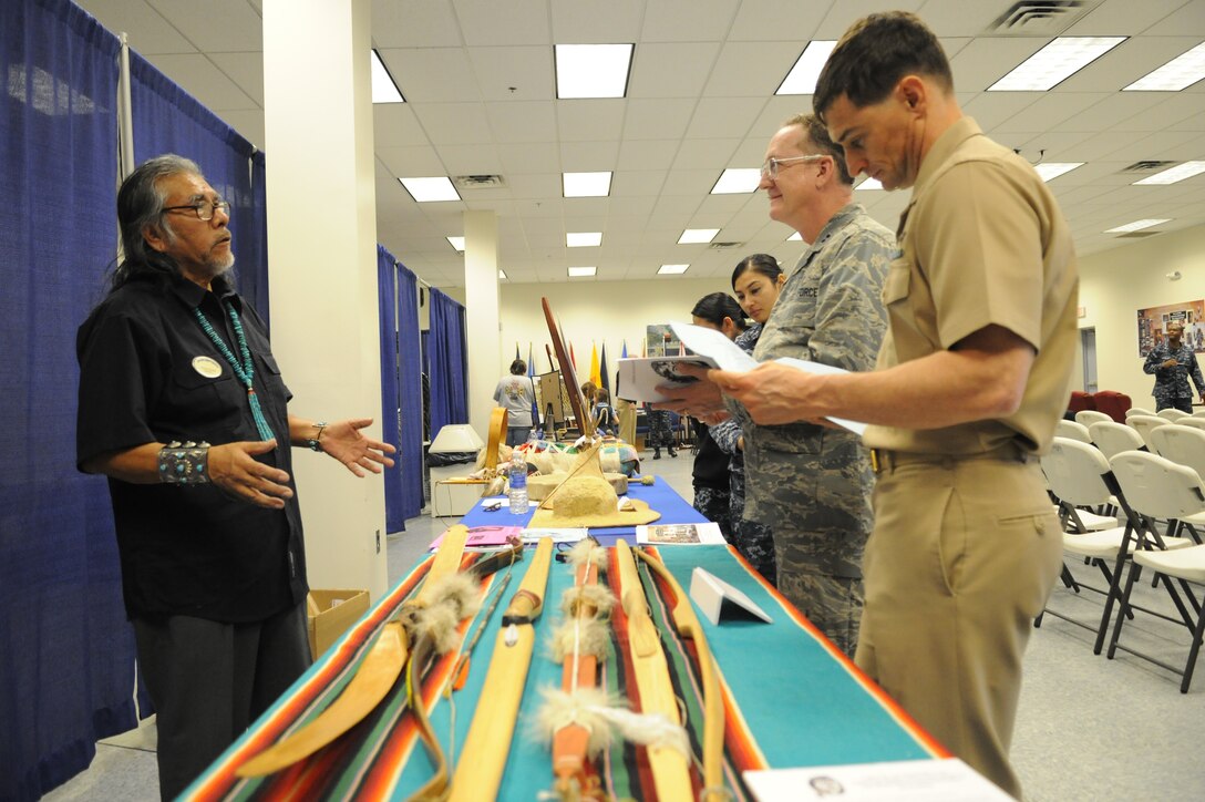 Retired U.S. Air Force Senior Master Sgt. Chuck Tsinnie explains Native American culture to attendees at Joint Base Andrews, Md., Nov. 22, 2013. The artifacts Tsinnie displayed were just some of the cultural pieces that were available during the National Native American Heritage Month food sampling and artifact display. (U.S. Air Force Photo/Airman 1st Class Joshua R. M. Dewberry) 