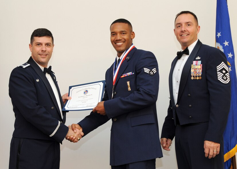 Senior Airman Scott Hewlett Jr., 2nd Munitions Squadron, receives an Airman Leadership School graduation certificate from Col. Andrew Gebara, 2nd Bomb Wing commander, on Barksdale Air Force Base, La., Nov. 21, 2013. (U.S. Air Force photo/Senior Airman Joseph A. Pagán Jr.)