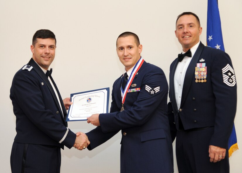 Senior Airman Kevin Branson, 2nd Aircraft Maintenance Squadron, receives an Airman Leadership School graduation certificate from Col. Andrew Gebara, 2nd Bomb Wing commander, on Barksdale Air Force Base, La., Nov. 21, 2013. (U.S. Air Force photo/Senior Airman Joseph A. Pagán Jr.)