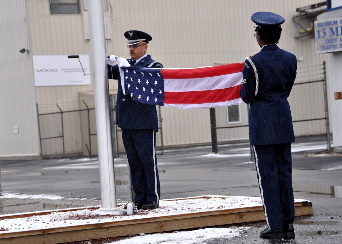 Tech. Sgt. Thomas Perrault and Senior Airman Latasha Cain, Niagara Falls Base Honor Guard, attach The Colors during a flag pole dedication ceremony at the Moog In Space Propulsion facility, Niagara Falls N.Y.  (U.S. Air Force photo by Master Sgt. Kevin Nichols)