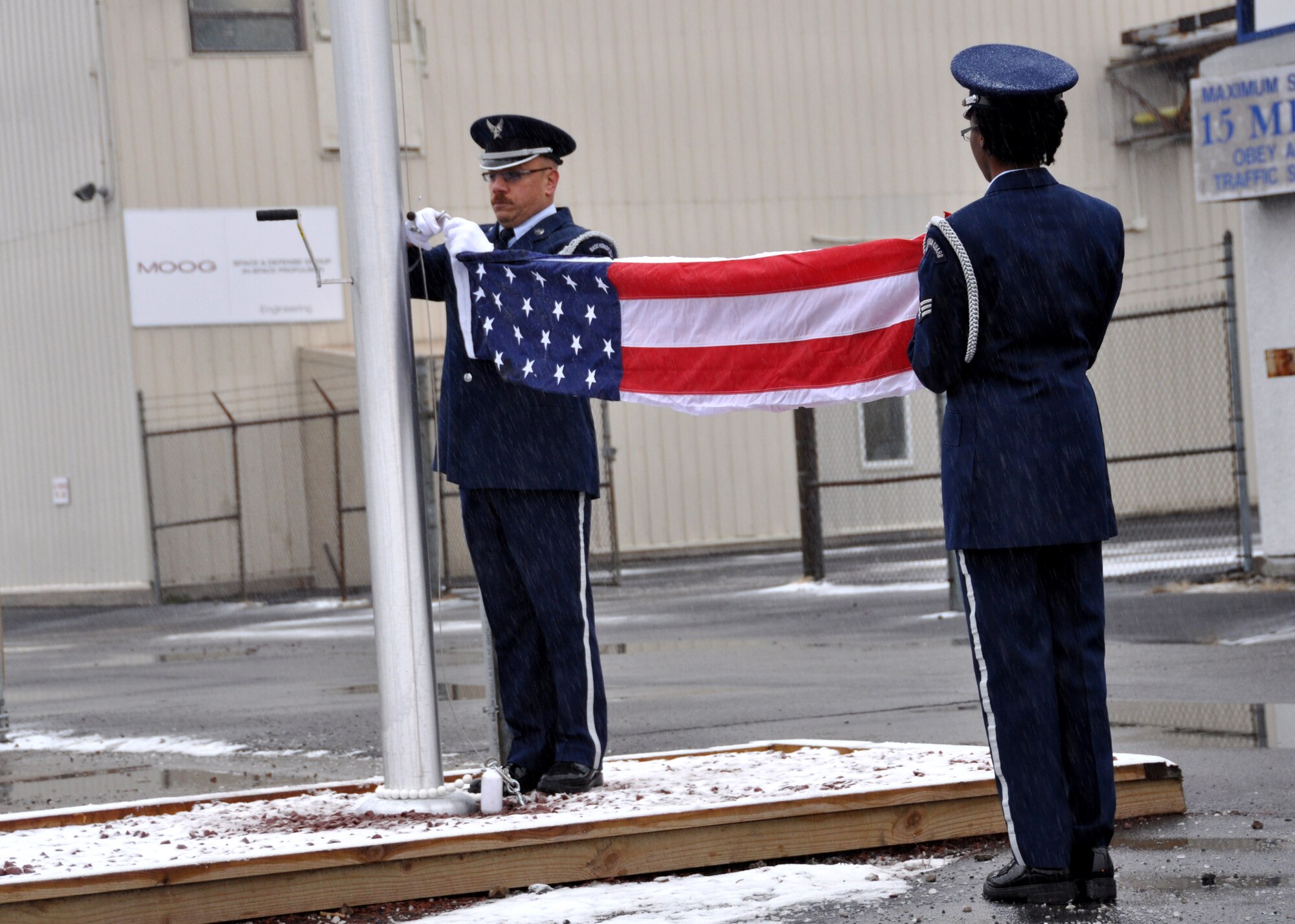 Tech. Sgt. Thomas Perrault and Senior Airman Latasha Cain, Niagara Falls Base Honor Guard, attach The Colors during a flag pole dedication ceremony at the Moog In Space Propulsion facility, Niagara Falls N.Y.  (U.S. Air Force photo by Master Sgt. Kevin Nichols)