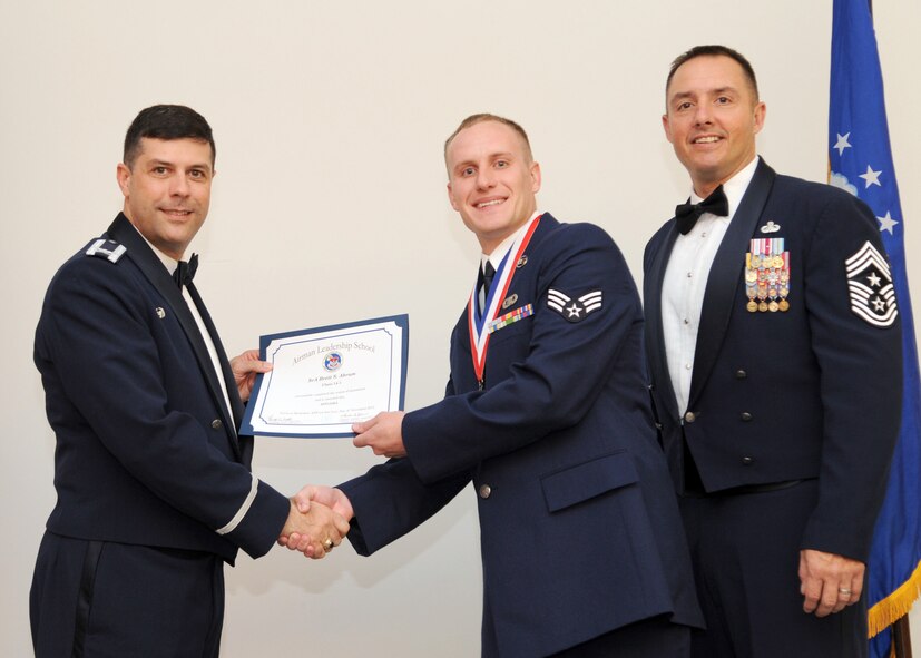 Senior Airman Brett Abram, 26th Operational Weather Squadron, receives an Airman Leadership School graduation certificate from Col. Andrew Gebara, 2nd Bomb Wing commander, on Barksdale Air Force Base, La., Nov. 21, 2013. (U.S. Air Force photo/Senior Airman Joseph A. Pagán Jr.)