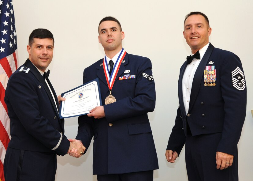 Senior Airman Gerald Marshall, 2nd Comptroller Squadron, receives an Airman Leadership School graduation certificate from Col. Andrew Gebara, 2nd Bomb Wing commander, on Barksdale Air Force Base, La., Nov. 21, 2013. (U.S. Air Force photo/Senior Airman Joseph A. Pagán Jr.)