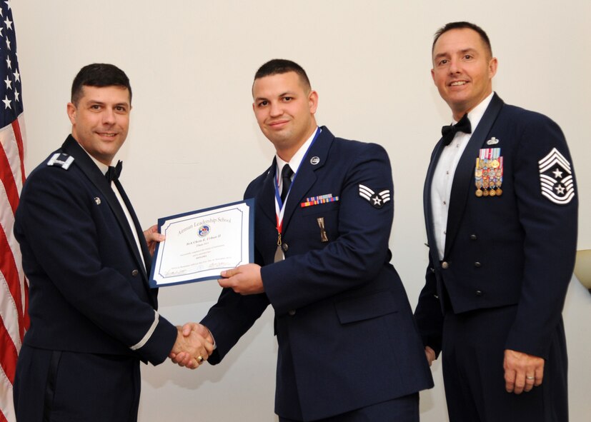 Senior Airman Chris Urban II, 2nd Munitions Squadron, receives an Airman Leadership School graduation certificate from Col. Andrew Gebara, 2nd Bomb Wing commander, on Barksdale Air Force Base, La., Nov. 21, 2013. (U.S. Air Force photo/Senior Airman Joseph A. Pag?n Jr.)