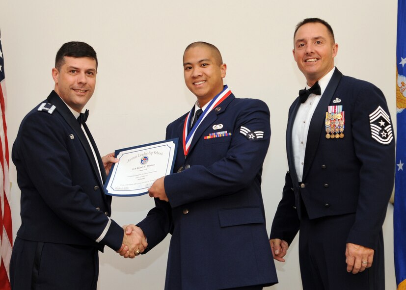 Senior Airman Randy Rosimo, 26th Operational Weather Squadron, receives an Airman Leadership School graduation certificate from Col. Andrew Gebara, 2nd Bomb Wing commander, on Barksdale Air Force Base, La., Nov. 21, 2013. (U.S. Air Force photo/Senior Airman Joseph A. Pagán Jr.)