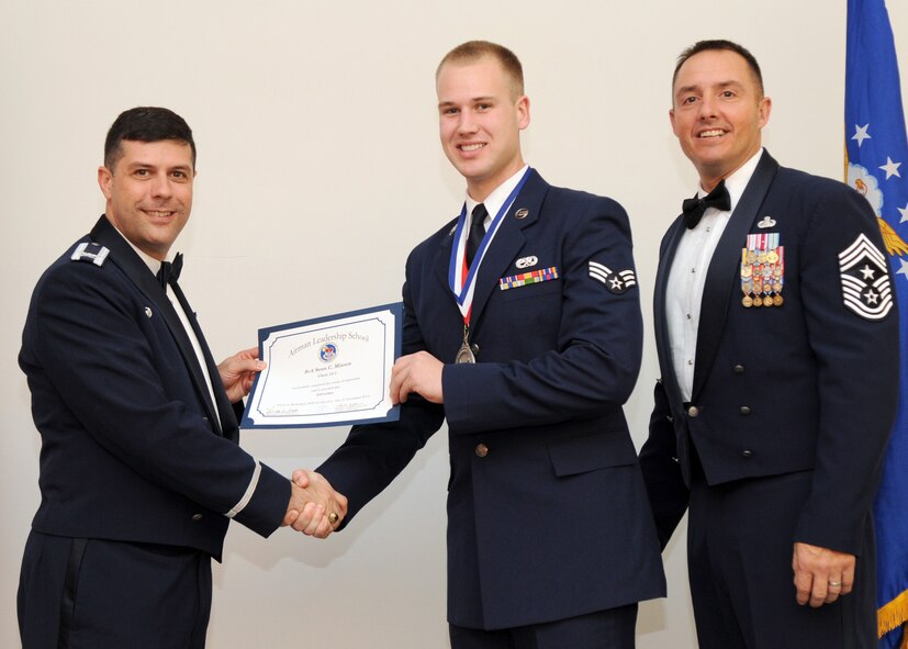 Senior Airman Sean Minnis, 2nd Aircraft Maintenance Squadron, receives an Airman Leadership School graduation certificate from Col. Andrew Gebara, 2nd Bomb Wing commander, on Barksdale Air Force Base, La., Nov. 21, 2013. (U.S. Air Force photo/Senior Airman Joseph A. Pagán Jr.)