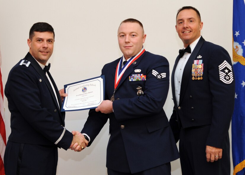 Senior Airman Edward Hatten, 2nd Security Forces Squadron, receives an Airman Leadership School graduation certificate from Col. Andrew Gebara, 2nd Bomb Wing commander, on Barksdale Air Force Base, La., Nov. 21, 2013. (U.S. Air Force photo/Senior Airman Joseph A. Pagán Jr.)