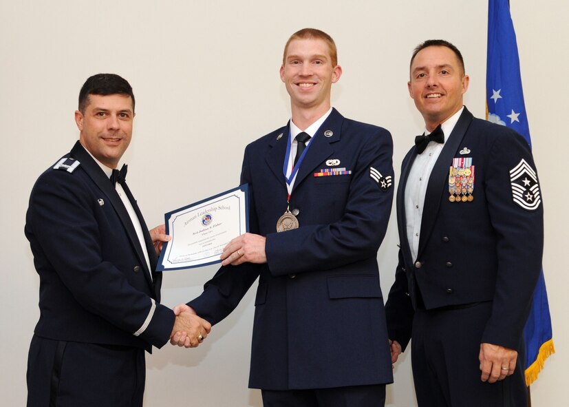 Senior Airman Joshua Fisher, 2nd Maintenance Squadron, receives an Airman Leadership School graduation certificate from Col. Andrew Gebara, 2nd Bomb Wing commander, on Barksdale Air Force Base, La., Nov. 21, 2013. (U.S. Air Force photo/Senior Airman Joseph A. Pagán Jr.)
