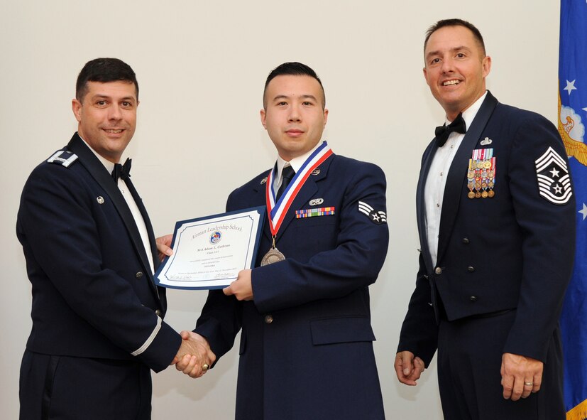 Senior Airman Adam Cothran, 2nd Maintenance Squadron, receives an Airman Leadership School graduation certificate from Col. Andrew Gebara, 2nd Bomb Wing commander, on Barksdale Air Force Base, La., Nov. 21, 2013. (U.S. Air Force photo/Senior Airman Joseph A. Pagán Jr.)