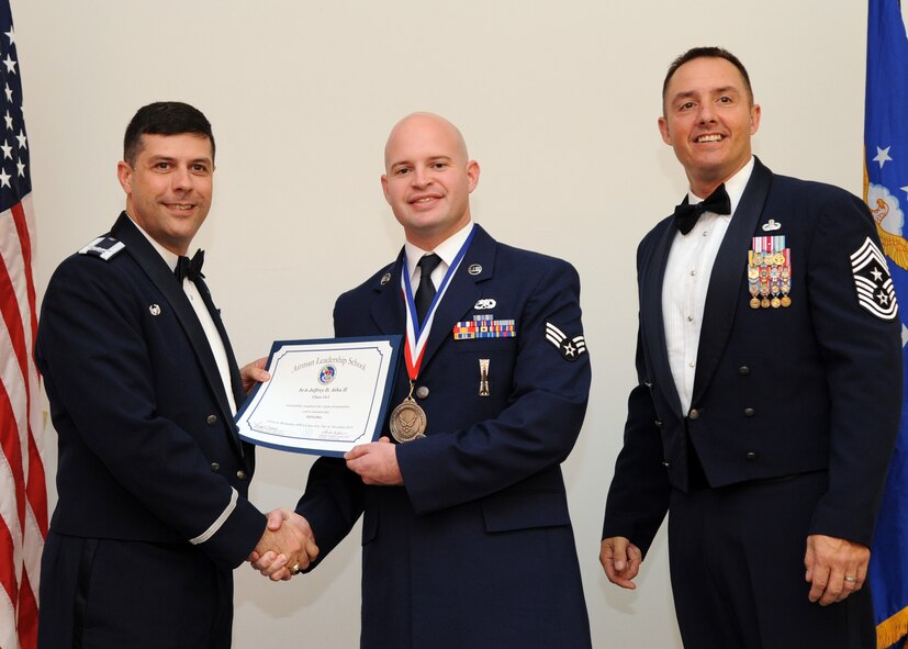 Senior Airman Jeffrey Atha II, 2nd Aircraft Maintenance Squadron, receives an Airman Leadership School graduation certificate from Col. Andrew Gebara, 2nd Bomb Wing commander, on Barksdale Air Force Base, La., Nov. 21, 2013. (U.S. Air Force photo/Senior Airman Joseph A. Pagán Jr.)